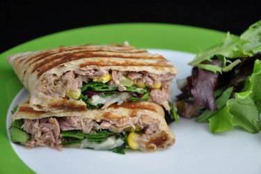 Přeložená celozrná placka nebo tortilla plněná tuňákovou směsí